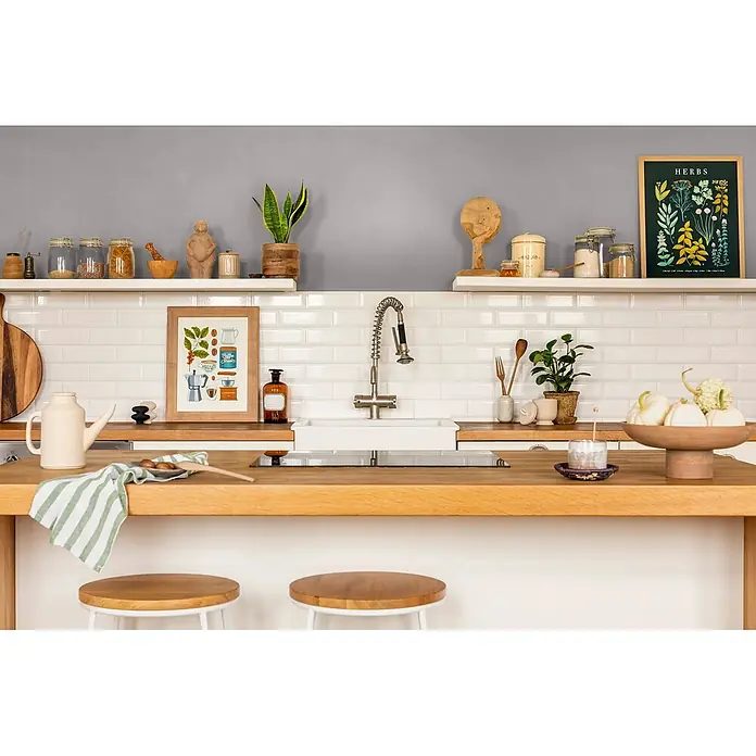 Caleo Color Wandfarbe Lehmfarbe Graureiher - Graureiher, Matt, 0,15 l - Moderne Küche mit heller Holz-Arbeitsplatte, integrierter Spüle und Herd, weißem Metrofliesen-Spritzschutz und offenen Regalen.