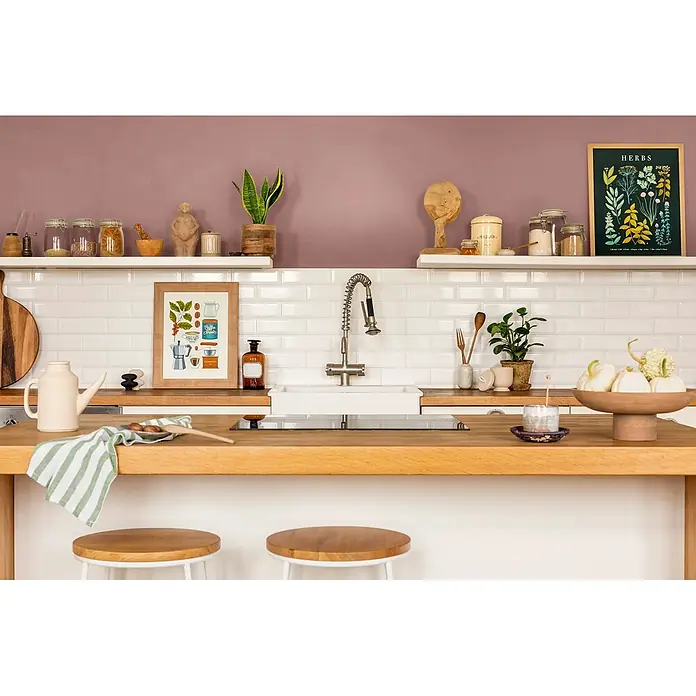 Caleo Color Wandfarbe Lehmfarbe Puder - Puder, Matt, 2,25 l - Helle Kücheninsel aus Holz mit integriertem Spülbecken und Kochfeld, als Arbeitsfläche und Sitzbereich mit Hockern genutzt.