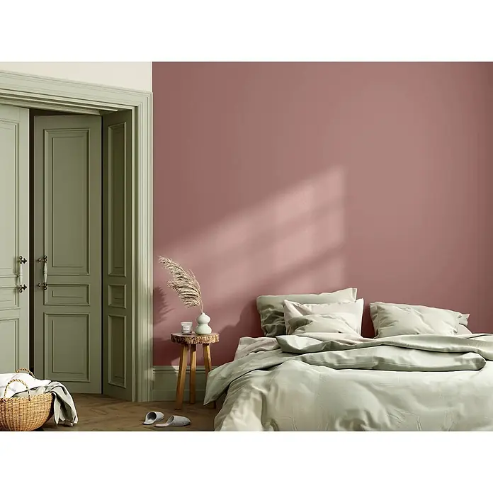 Caleo Color Wandfarbe Lehmfarbe Puder - Puder, Matt, 2,25 l - Salbeigrünes Bettzeug auf einem Bett in einem gemütlichen Schlafzimmer.