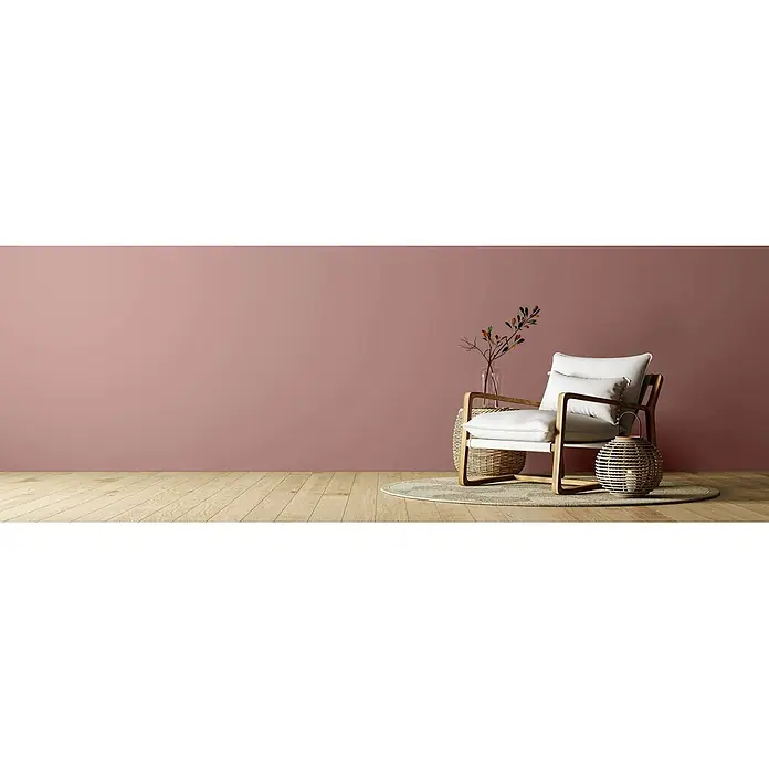 Caleo Color Wandfarbe Lehmfarbe Puder - Puder, Matt, 5 l - Moderner Sessel mit hellem Holzrahmen und weißen Kissen, in einem gemütlichen Raum mit rosa Wand und Holzfußboden.
