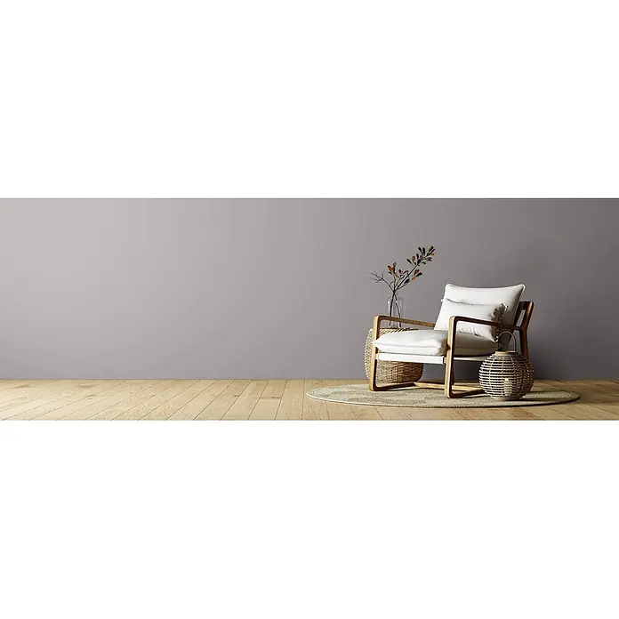 Caleo Color Wandfarbe Lehmfarbe Graureiher - Graureiher, Matt, 0,15 l - Sessel mit hellem Holzrahmen und weißen Kissen, mit geflochtenem Korb und Laterne.