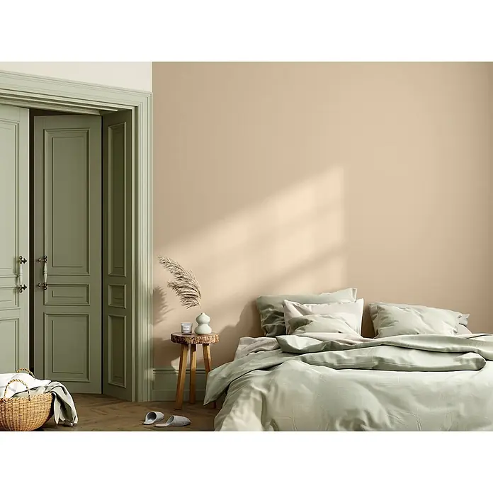 Caleo Color Wandfarbe Lehmfarbe Königsfelsen - Königsfelsen, Matt, 0,15 l - Ein ruhiges Schlafzimmer mit hellgrüner Bettwäsche und Türen vor einer warmen beigefarbenen Wand.