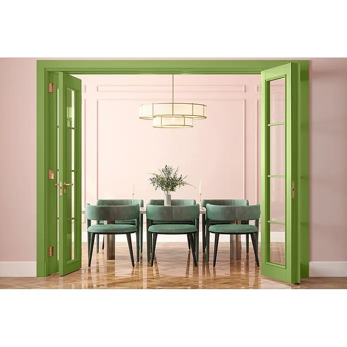 Caleo Color Buntlack Gingko - Gingko, Seidenmatt, 0,68 l, Wasserbasiert - Offene grüne Flügeltüren mit Goldbeschlägen führen in ein Esszimmer mit rosa Wänden und grünen Samtstühlen.