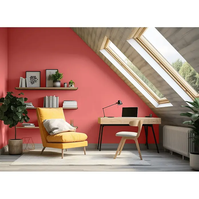 Caleo Color Wandfarbe Lehmfarbe Mohnblume - Mohnblume, Matt, 0,15 l - Modernes Dachbüro mit lebhaften Korallenwänden, Holzschreibtisch, Stuhl und einem sonnigen gelben Sessel unter großen Dachfenstern.