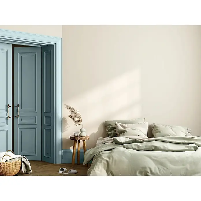 Caleo Color Buntlack Eisblume - Eisblume, Seidenmatt, 0,68 l, Wasserbasiert - Helle grüne Bettwäsche auf einem Bett in einem ruhigen Schlafzimmer mit beigen Wänden und blauen Türen.