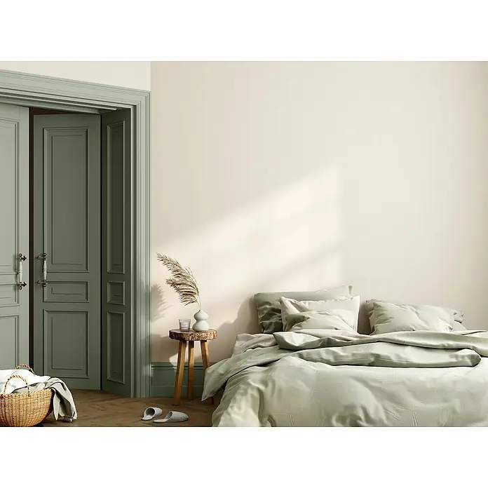Caleo Color Buntlack Jade - Jade, Seidenmatt, 0,68 l, Wasserbasiert - Hellgrüne Bettwäsche auf einem Bett in einem minimalistischen Schlafzimmer mit salbeigrünen Türen und Holztischchen.