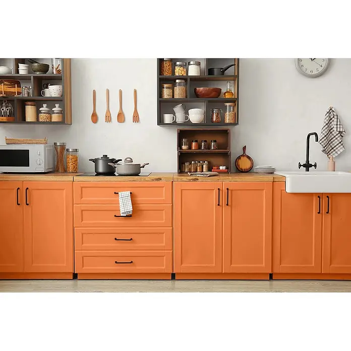 Caleo Color Buntlack Wüstenfuchs - Wüstenfuchs, Seidenmatt, 0,68 l, Wasserbasiert - Moderne Küche mit leuchtend orangefarbenen Unterschränken, Arbeitsplatten aus Holz und offenen Wandregalen, ausgestattet mit Mikrowelle, Kochfeld und Spüle.