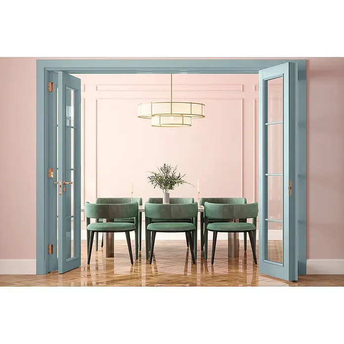 Caleo Color Buntlack Eisenherz - Eisenherz, Seidenmatt, 0,68 l, Wasserbasiert - Elegantes Esszimmer mit offenen blauen Flügeltüren, einem Tisch mit grünen Samtstühlen unter einem goldenen Kronleuchter.
