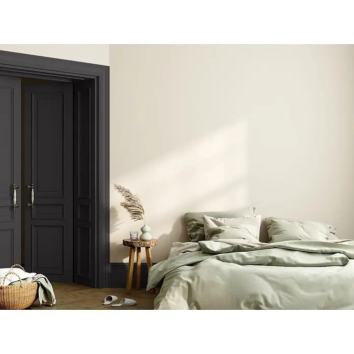 Caleo Color Buntlack Ebenholz - Ebenholz, Seidenmatt, 0,68 l, Wasserbasiert - Ein Bett mit weicher, hellgrüner Leinenbettwäsche in einem minimalistischen Schlafzimmer.