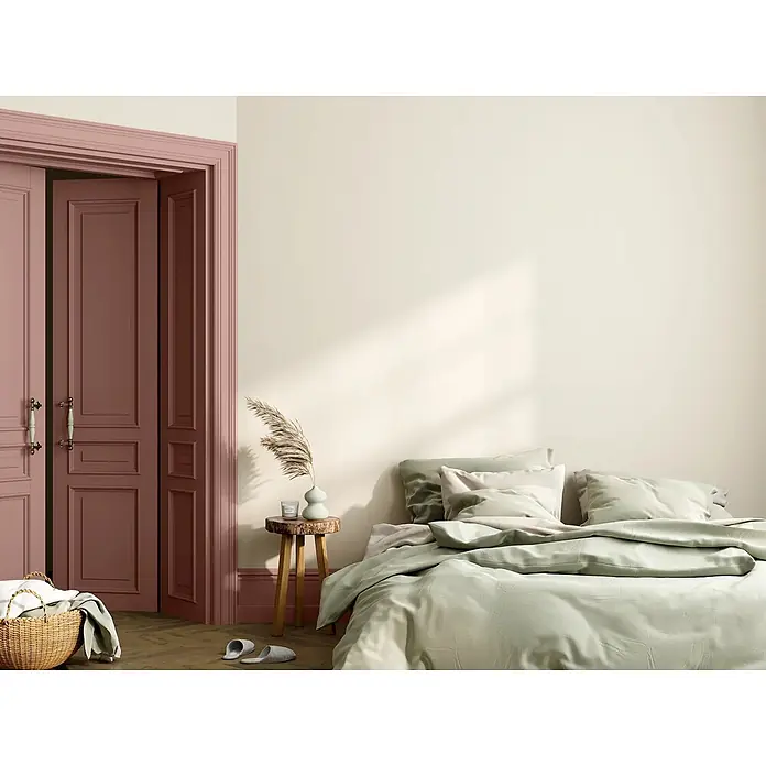Caleo Color Buntlack Magnolie - Magnolie, Seidenmatt, 0,15 l, Wasserbasiert - Schlafzimmer mit Bett in weicher grüner Bettwäsche, hellen cremefarbenen Wänden und eleganten weinroten Türen, das eine ruhige Atmosphäre schafft.