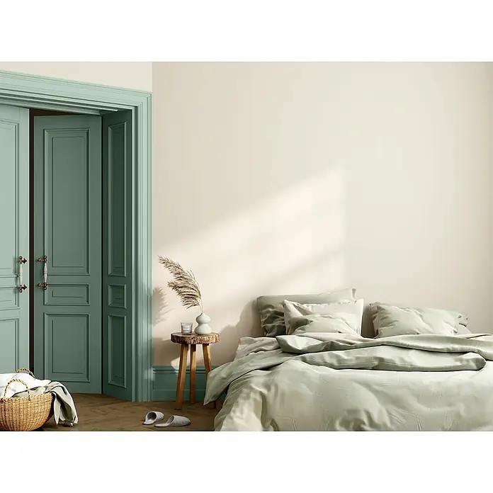 Caleo Color Buntlack Novembernebel - Novembernebel, Seidenmatt, 0,68 l, Wasserbasiert - Hellgrüne Bettwäsche auf einem Bett und elegante salbeigrüne Kassettentüren in einem ruhigen Schlafzimmer.