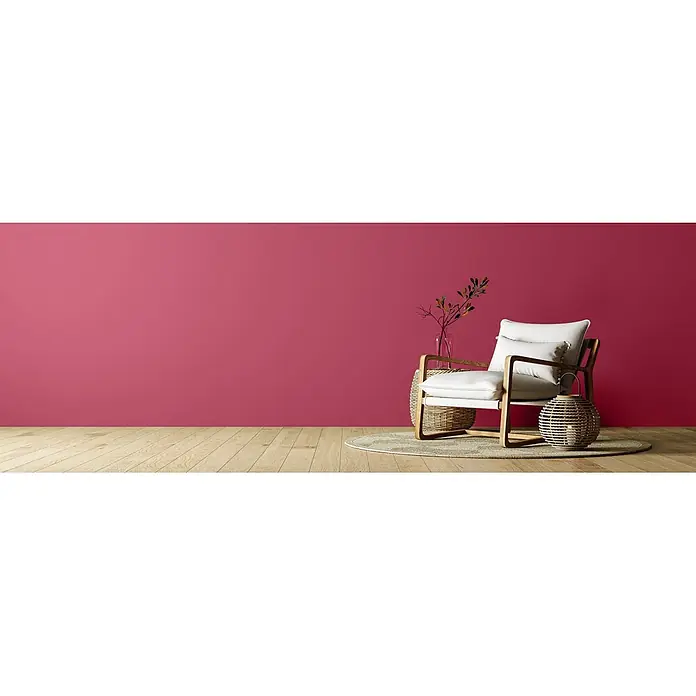 Caleo Color Wandfarbe Lehmfarbe Drachenglut - Drachenglut, Matt, 0,15 l - Moderner heller Sessel mit Holzrahmen in einem gemütlichen Raum mit roter Wand und Holzboden, verziert mit Weidenakzenten.
