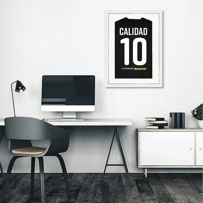 Cuadro enmarcado para camiseta - Blanco, An x Al: 40 x 56 cm - Lámina enmarcada de camiseta negra con 'CALIDAD 10' y 'De PROFESIONAL', colgada sobre escritorio moderno.