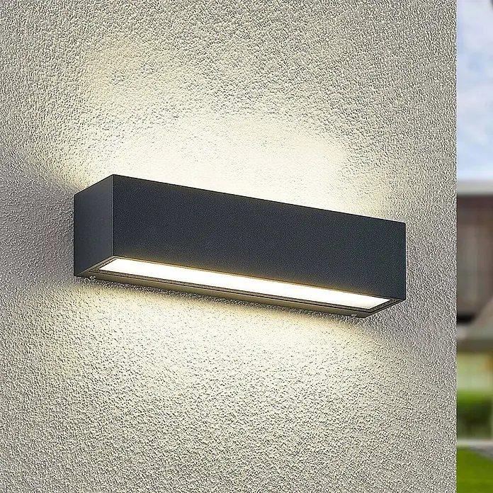 Arcchio LED Wandleuchte aussen in anthrazit, Aussenlampe Wand -  - Dunkelgraue rechteckige Außenwandleuchte an einer strukturierten Wand, strahlt warmes Licht nach oben, unten und vorne ab.