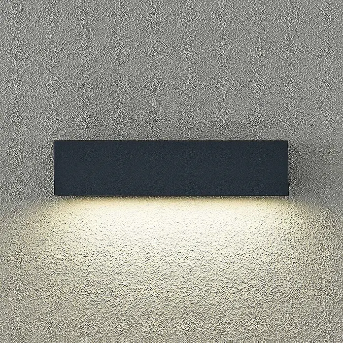 Arcchio LED Wandleuchte aussen in anthrazit, Aussenlampe Wand -  - Dunkelgraue rechteckige Wandleuchte, die warmes Licht nach unten auf eine strukturierte Wand wirft.