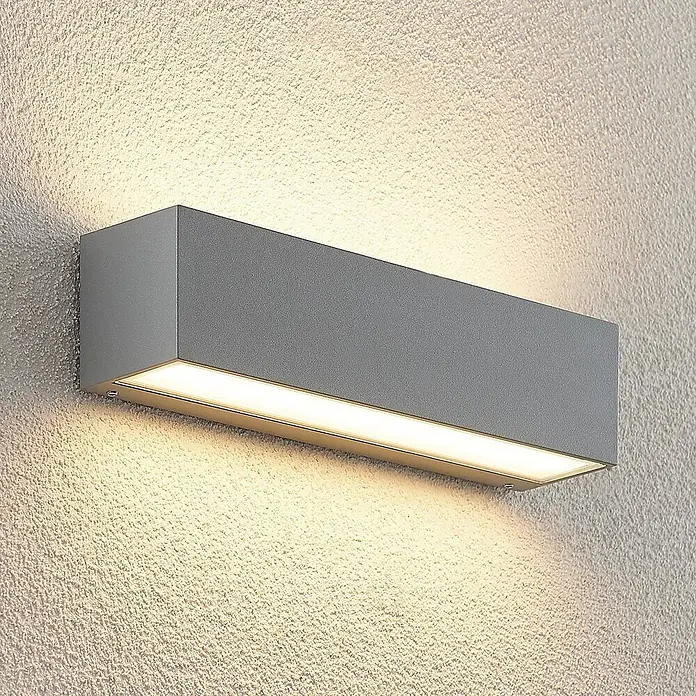 Lucande LED Wandleuchte aussen in silber, Aussenlampe Wand -  - Graue rechteckige Wandleuchte, die warmes Licht nach oben und unten auf eine strukturierte Wand strahlt.