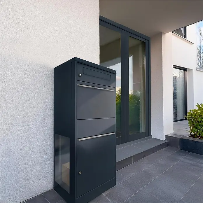Metzler Paketbox BRFK BISPO SF - L x B x H: 37 x 50,2 x 112 cm, Anthrazit, Stahl, Paketfach, Mit Seitenfenster - Anthrazitfarbener Paketbriefkasten mit Einwurfschlitz und Glaspaneel, an modernem Hauseingang installiert.