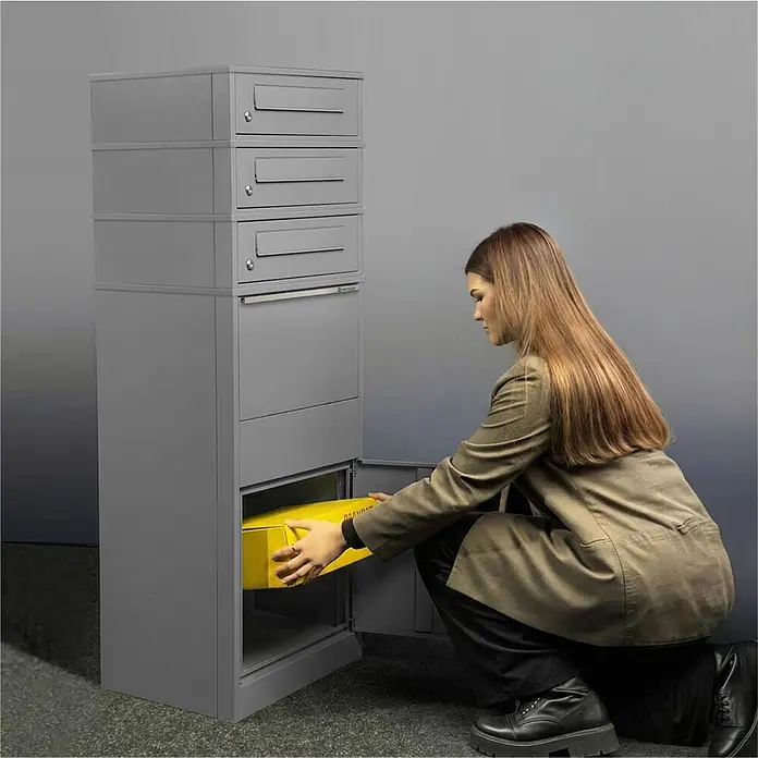 Metzler Paketbox 3 BRFK BISPO - L x B x H: 37,4 x 50,3 x 147,7 cm, Graualuminium, Stahl, Paketfach, 3 Briefkastenfächer - Graue Metall-Paketbox mit mehreren Fächern. Eine Person legt ein gelbes Paket in die große untere Öffnung.