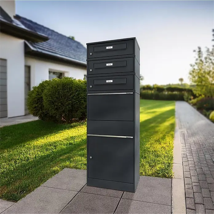 Metzler Paketbox 3 BRFK BISPO RE - L x B x H: 37,4 x 50,3 x 147,7 cm, Anthrazit, Stahl, Paketfach, 3 Briefkastenfächer und Namensschildern - Hohe, dunkelgraue Mehrfach-Briefkastenanlage aus Metall im Freien vor einem Haus.