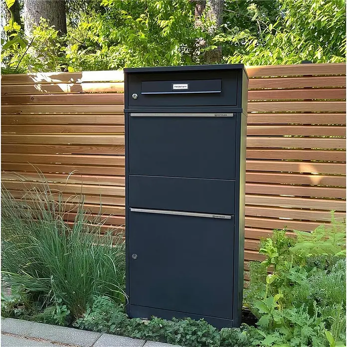 Metzler Paketbox BRFK BISPO RE - L x B x H: 37,4 x 50,3 x 112,9 cm, Anthrazit, Stahl, Paketfach - Hoher, dunkelgrauer Metallbriefkasten mit mehreren Fächern für Post und Pakete, im Grünen stehend.