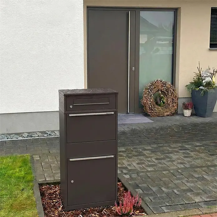 Metzler Paketbox BRFK BISPO - L x B x H: 37,4 x 50,3 x 112,9 cm, Eisenglimmer, Stahl, Paketfach - Dunkelbraunes Mehrfach-Briefkastensystem im Freien vor einem modernen Hauseingang.
