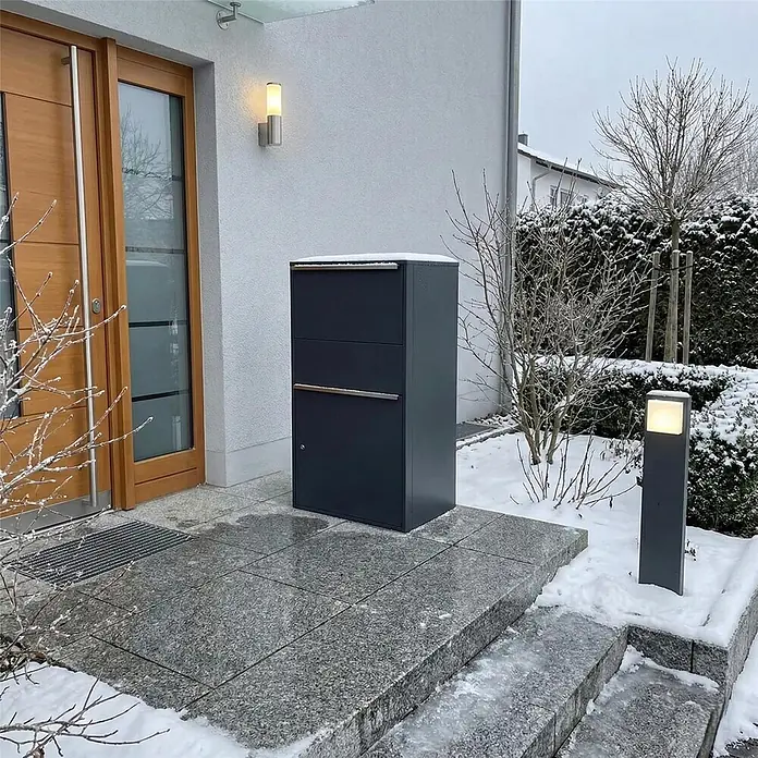 Metzler Paketbox XL BISPO MAX - L x B x H: 45,4 x 72 x 128,5 cm, Anthrazit, Stahl, Paketfach - Dunkelgraue Paketbox mit silbernen Griffen, im Winter vor einem Hauseingang platziert.