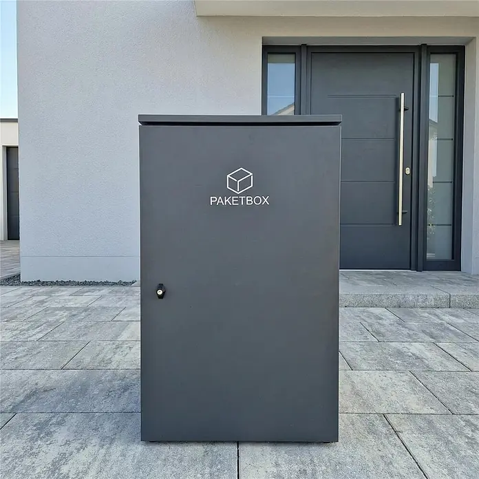 Metzler Paketbox XXL BEN - L x B x H: 81,2 x 68,4 x 123,3 cm, Anthrazit, Stahl - Dunkelgraue Paketbox auf einer modernen Terrasse neben einem Hauseingang.