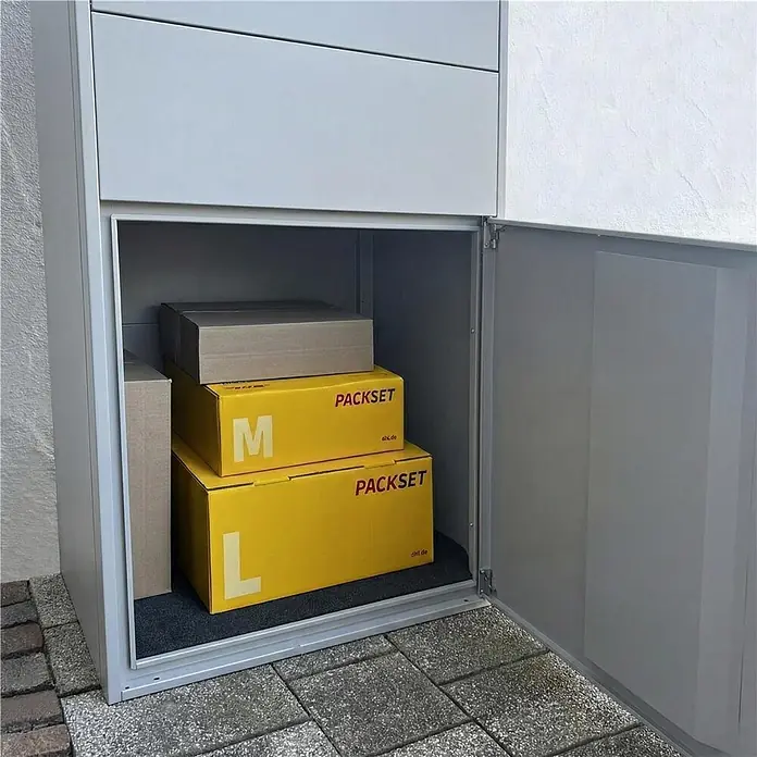 Metzler Paketbox XL BRFK BISPO MAX - L x B x H: 45,4 x 72 x 145 cm, Graualuminium, Stahl, Paketfach - Graue Paketbox aus Metall mit geöffneter Tür, die mehrere Kartonpakete im Inneren zeigt. Zur sicheren Paketannahme.