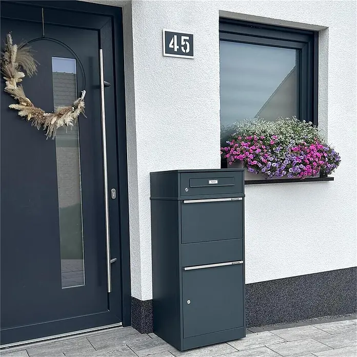 Metzler Paketbox BRFK BISPO RE - L x B x H: 37,4 x 50,3 x 112,9 cm, Anthrazit, Stahl, Paketfach - Dunkelgrauer freistehender Brief- und Paketkasten neben einem Hauseingang, bereit für Post und Pakete.