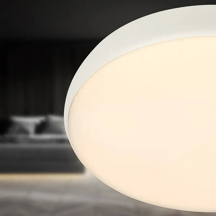 Brilo Plafón LED redondo Nikan - 20 W, Ø x Al: 35 x 8,5 cm, Blanco, Blanco neutro - Lámpara de techo redonda y blanca con un difusor cálido y brillante, iluminando un fondo de dormitorio difuminado.