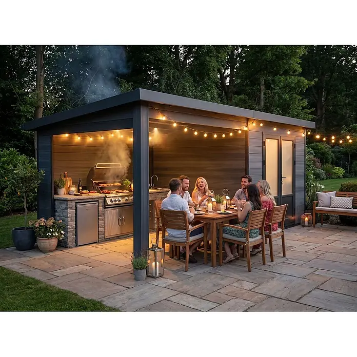 Fjordholz Gartenhaus Style DeLuxe - Außenmaß inkl. Dachüberstand (B x T): 571 x 327 cm, Aluminium, Anthrazit/grau - Moderne dunkelgraue Outdoor-Küchenstruktur mit Grill, Spüle und Essbereich, beleuchtet von Lichterketten, wo Menschen essen.