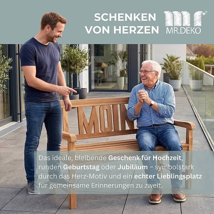 Gartenbank Moin Teak 120cm -  - Helle Holzgartenbank mit „MOIN“-Schriftzug in der Lehne. Ein älterer Mann sitzt darauf, ein jüngerer zeigt darauf, als Geschenkidee.
