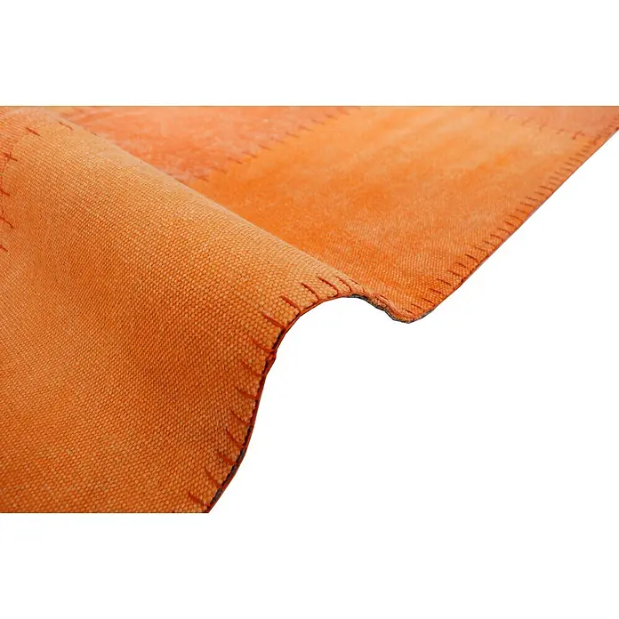 Kayoom Flachgewebeteppich Lyrical 110 - Multi/Orange, 230 x 160 cm, 100 % Baumwolle - Nahaufnahme eines teilweise gerollten oder gefalteten, orangefarbenen gewebten Textils, möglicherweise eines Teppichs, mit sichtbaren Nähten.