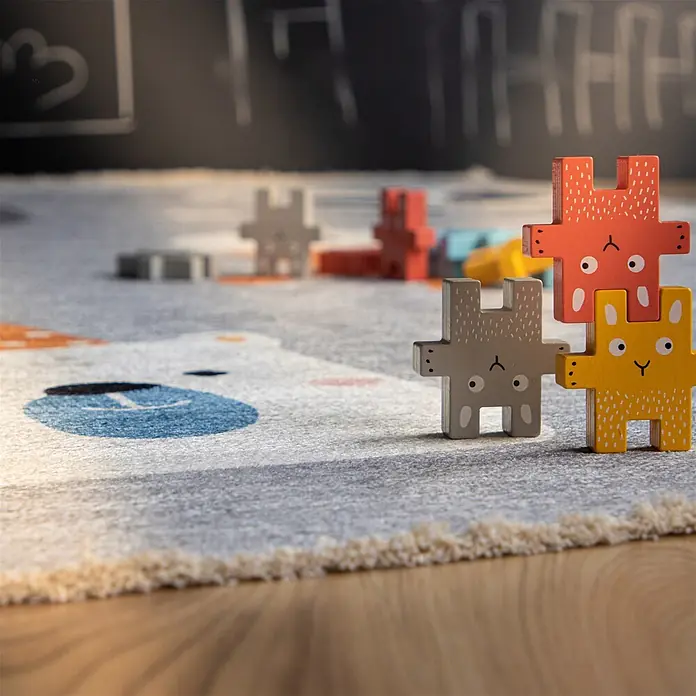 Kayoom Kinderteppich Joanna 613 - Multi, 170 x 115 cm, 70 % Baumwolle, 30 % Polyester - Bunte Holz-Tier-Stapelblöcke (rot, gelb, grau) auf einem Kinder-Spielteppich.
