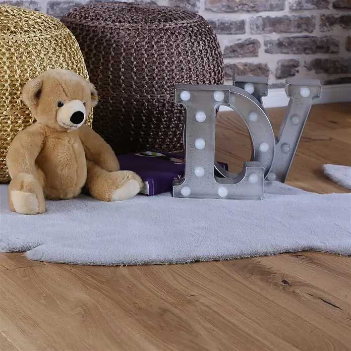 Kayoom Kinderteppich Lille 862 - Grau, 114 x 66 cm, 100 % Polyester - Hellgrauer, weicher, flauschiger Teppich auf Holzboden in gemütlicher Zimmereinrichtung.