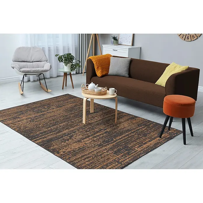 Kayoom Flachgewebeteppich Kalea 125 - Gelb, 170 x 120 cm, 100 % Polyester - Abstrakt gemusterter Teppich in Dunkelbraun und Goldtönen in einem gemütlichen Wohnzimmer.