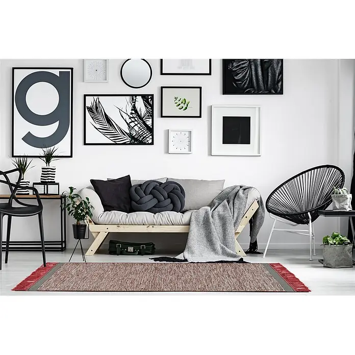 Kayoom Fransenteppich Nomad 8064 - Grau/Rot, 240 x 170 cm, 70 % Wolle, 25 % Baumwolle, 5 % Viskose - Ein rechteckiger rot-grau gestreifter Teppich mit roten Fransen auf dem Boden eines modernen Wohnzimmers.