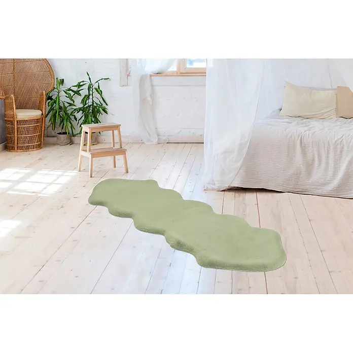 Kayoom Kunstfell Rabbit Double Sheepskin - Mint, 180 x 60 cm, 100 % Polyester - Ein wellenförmiger grüner Fellteppich auf hellem Holzboden in einem Schlafzimmer.