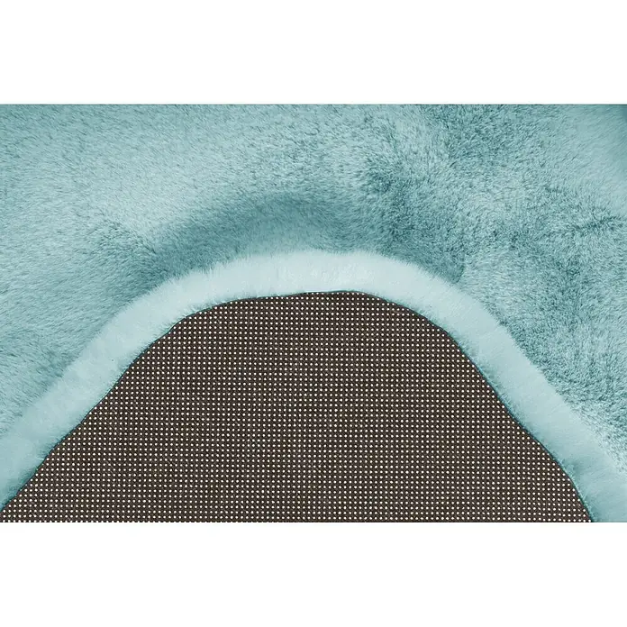 Kayoom Kunstfell Rabbit Double Sheepskin - Türkis, 180 x 60 cm, 100 % Polyester - Weicher, hellblauer Kunstfellteppich, teilweise umgeklappt, um die rutschfeste Punktbeschichtung zu zeigen.