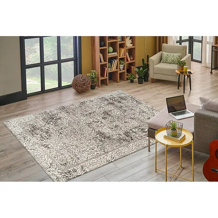 Kayoom Kurzflorteppich Davis 225 - Grau, 230 x 160 cm, 100 % Polyester - Grau-weißer ornamentaler Teppich im Used-Look auf hellem Holzboden, verschönert ein modernes Wohnzimmer.