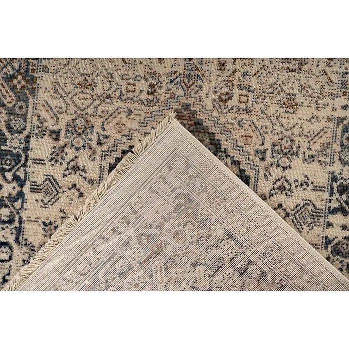 Kayoom Kurzflorteppich Charin 425 - Blau, 230 x 160 cm, 100 % Polypropylen - Beiger Teppich mit komplexen blauen, braunen und grauen Mustern, teilweise gefaltet, um die gewebte Rückseite und Fransen zu zeigen.
