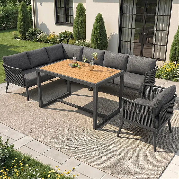 SONNENH Loungemöbel-Set - 6 -tlg., Eisen, Grau - Dunkelgraue Outdoor-Lounge- und Essgruppe mit Holztischplatte auf einer Terrasse, bestehend aus Ecksofa, zwei Sesseln und einem rechteckigen Tisch.