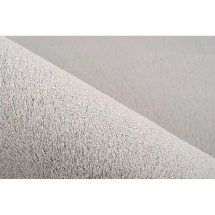 Kayoom Fellteppich Emperor 525 - Silber, 230 x 160 cm, 100 % Polyester - Gerollter hellgrauer Plüschstoff, der seine weiche, flauschige Textur zeigt.