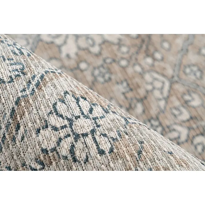 Kayoom Flachgewebeteppich Perry 125 - Khaki/Beige, 170 x 120 cm, 75 % Baumwolle, 25 % Polyester - Nahaufnahme eines gerollten Webteppichs mit beigen, blauen und braunen Mustern.
