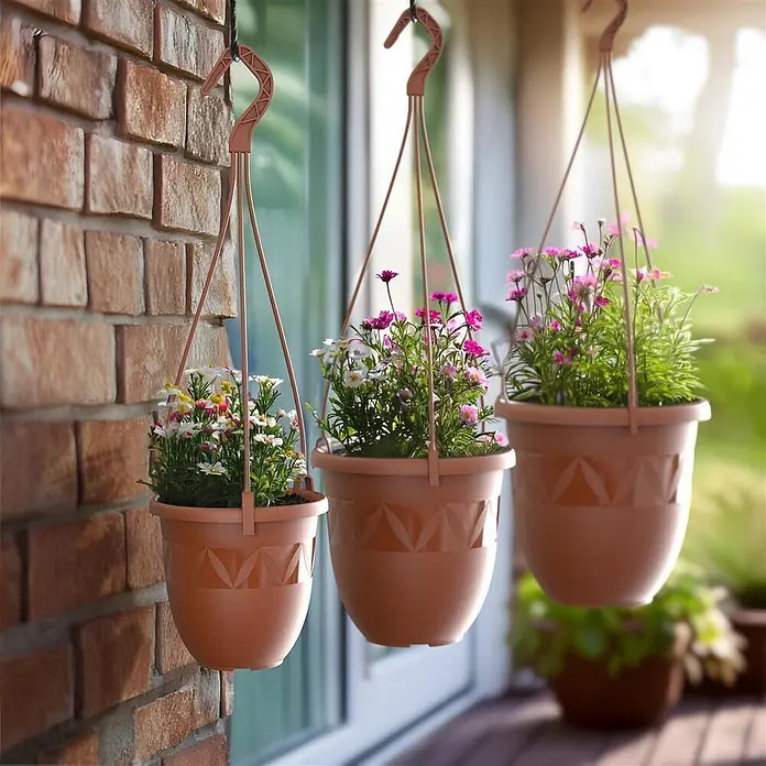 Plastard Blumenampel Ø 24 cm in Terrakotta mit Aufhänger, Deko Blumentopf - 1 Stk., Außenmaß (Ø x H): 24 x 20 cm, Kunststoff, Terrakotta - Drei terrakottafarbene Kunststoff-Hängepflanzgefäße mit bunten Blumen, draußen aufgehängt.