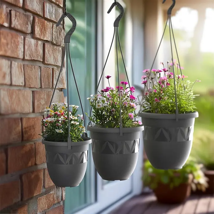 Plastard Blumenampel Ø 15 cm in Anthrazit mit Aufhänger, Deko Blumentopf - 1 Stk., Außenmaß (Ø x H): 15 x 13 cm, Kunststoff, Anthrazit - Drei graue Blumenampeln aus Kunststoff mit geometrischem Muster, gefüllt mit bunten Blumen, hängen draußen.