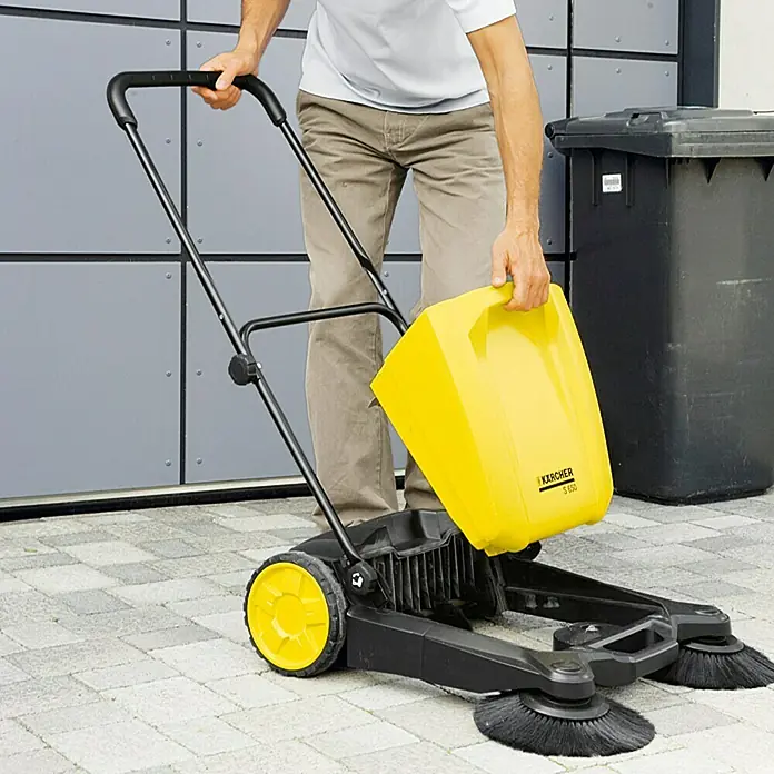 Kärcher Bolsa de aspiradora A 2004, A 2054 ME, A 2024 PT - 5 ud. - Un hombre vaciando el depósito de recogida amarillo de una barredora Kärcher S 650. Práctica para limpiar aceras y calzadas.
