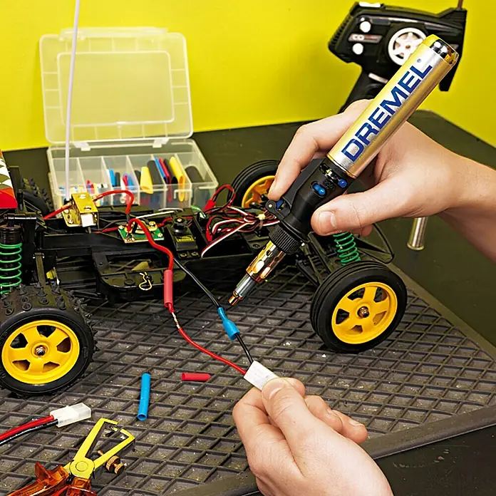 Dremel VersaTip Soldador a gas 2000-6 - Largo: 19 cm - Se está utilizando un soldador de butano Dremel para soldar cables en un coche radiocontrolado, mostrando precisión y versatilidad.