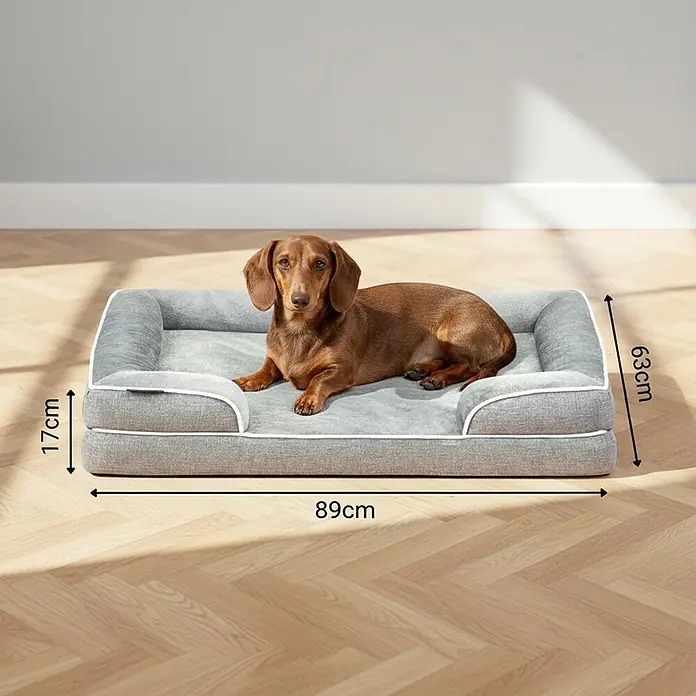 belviona Haustierbett - 63 x 89 x 17 cm, Textil, Grau - Grau gepolstertes Hundebett mit weißer Paspelierung, ein Dackel liegt darauf. Maße: 89x63x17cm.