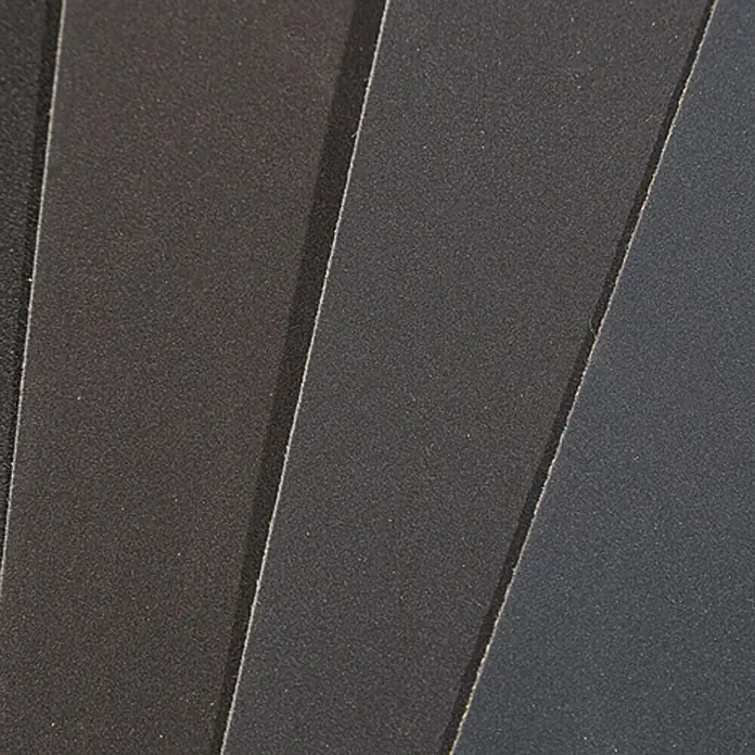 Craftomat Schleifpapier-Set - 16 Stk., Körnung: 280 - Nahaufnahme von verschiedenen Graustufen, die eine subtile Textur und Schattierungen des Produkts hervorheben. Perfekt für Designprojekte.
